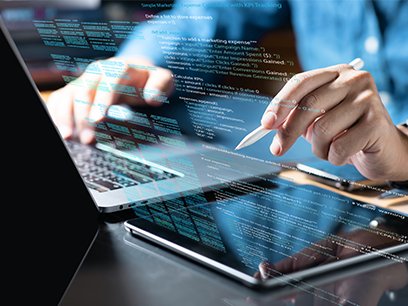 Im Vordergrund sieht man einen Laptop an dem eine Person sitzt, man sieht nur ihre Hände. Darüber ist etwas HTML-Code eingebelendet
