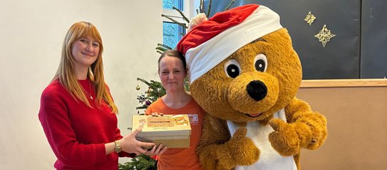 Vanessa Denke (IBYKUS AG) übergibt die gesammelten Spenden an bärenstark e.V.