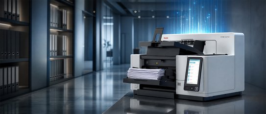 Professioneller Dokumentenscanner der Marke Kodak Alaris mit eingelegtem Papierstapel in einer modernen Büroumgebung. Blaue digitale Lichteffekte über dem Gerät symbolisieren automatisierte Dokumentenverarbeitung, Digitalisierung und effiziente Datenverarbeitung.