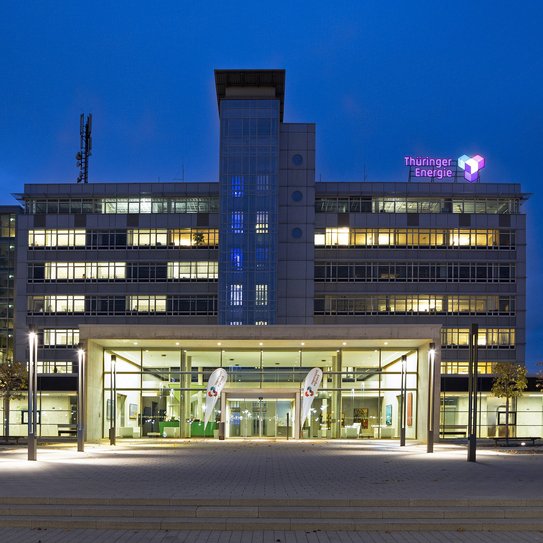 Frontalansicht auf die Unternehmenszentrale der TEAG Thüringer Energie AG bei Nacht.