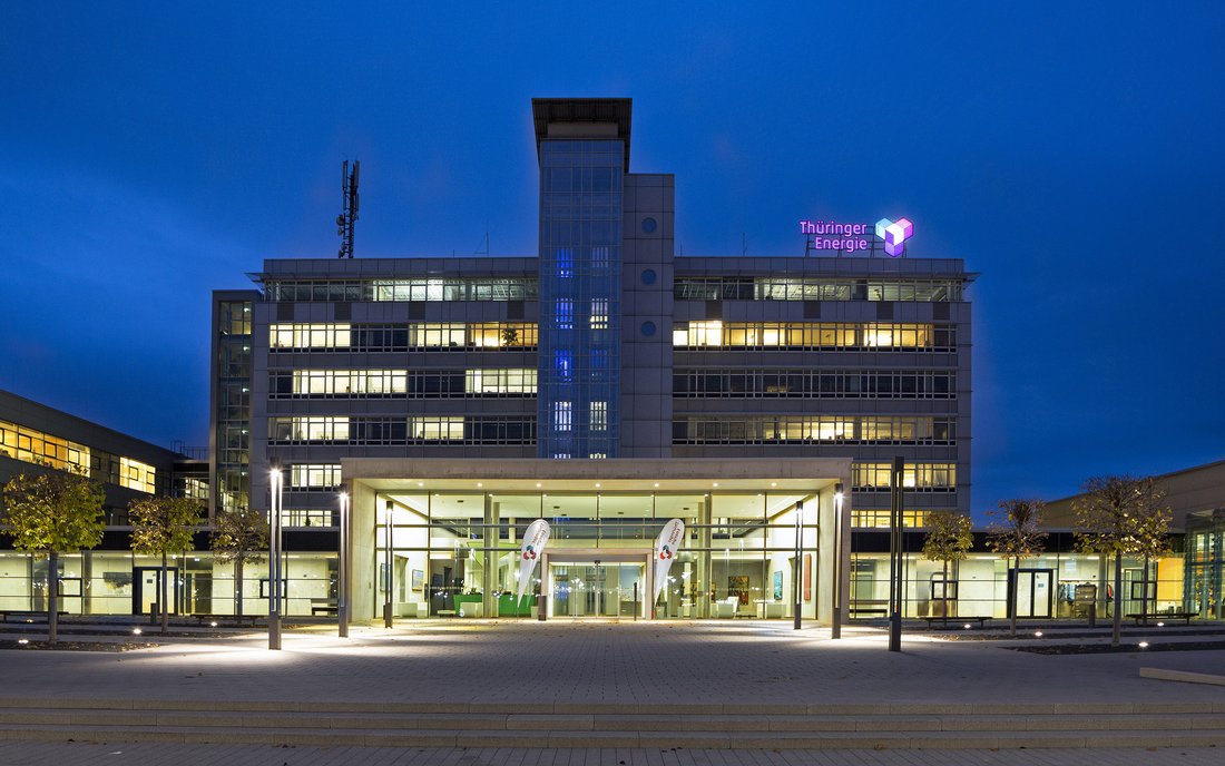 Frontalansicht auf die Unternehmenszentrale der TEAG Thüringer Energie AG bei Nacht.